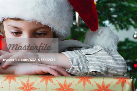 Boy resting head on Christmas present