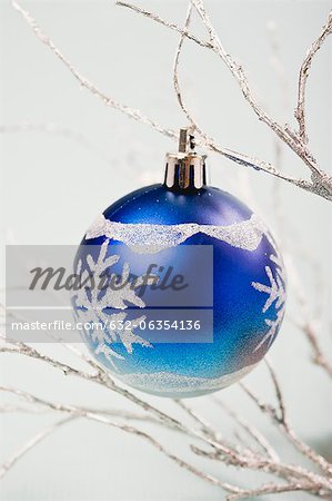 Blue bauble hanging from silver branches