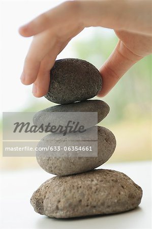 Hand stacking pebbles