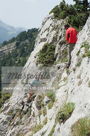 Hikers climbing on rock