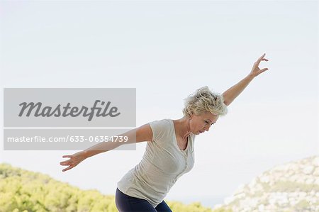 Mature woman exercising with arms outstretched