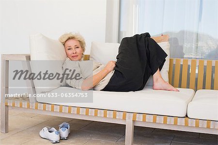Mature woman reclining on sofa