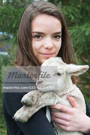 Teenage girl holding lamb