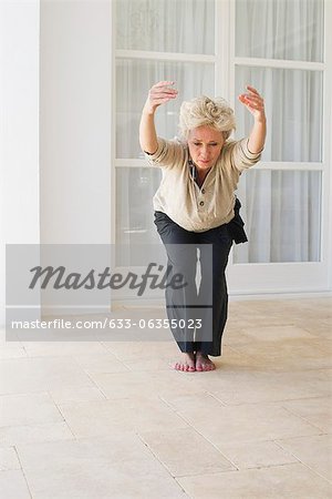 Reife Frau tun Yoga Stuhl-pose