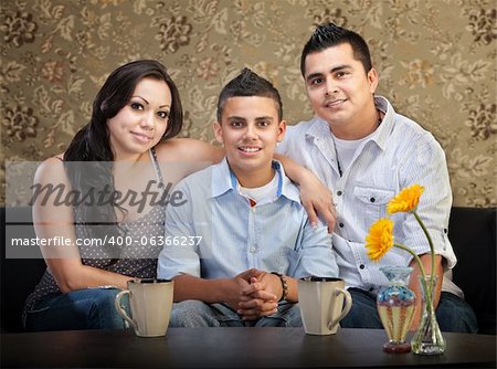 Smiling young Latino family of three sitting together
