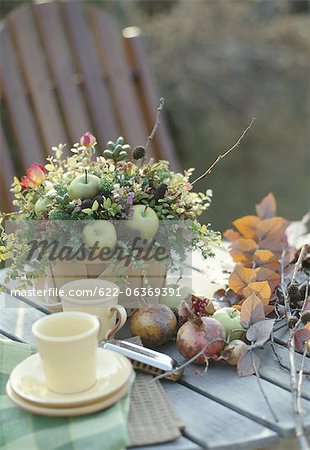 Autumn fruits, flowers and cup on a table