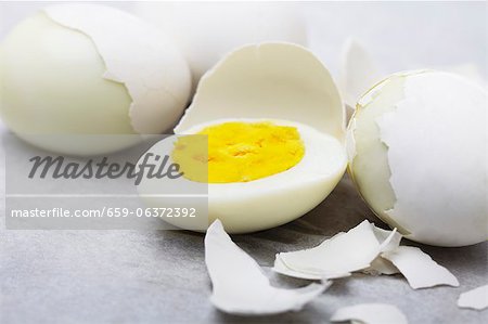 Hart gekochtes Käfig Eier; Einige teilweise geschält; Eine Hälfte
