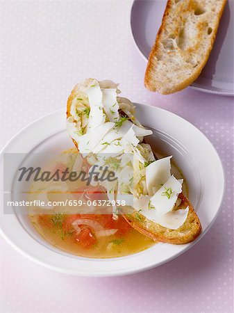 Fennel soup with tomatoes served with crostini topped with fennel and manchego cheese