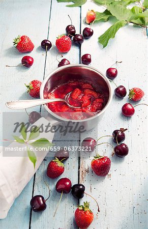 Strawberry jam in a pot, fresh cherries and strawberries