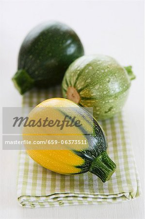 Mini courgettes in three colours on a tea towels