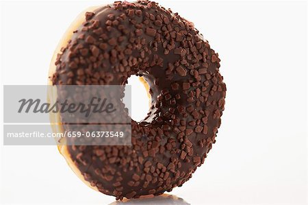 Un beignet avec glaçage au chocolat et vermicelles de chocolat