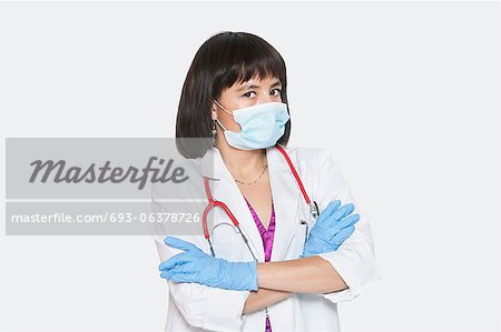 Porträt der Frau Tierarzt stehend Arme kreuzt über grauen Hintergrund