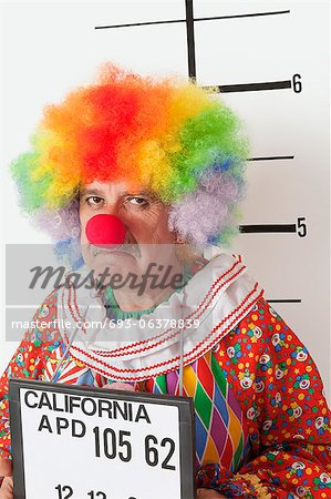 Portrait of angry senior clown during mug shot