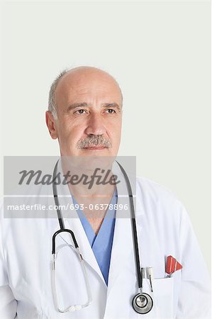 Männliche Oberarzt mit Stethoskop über dem grauen Hintergrund