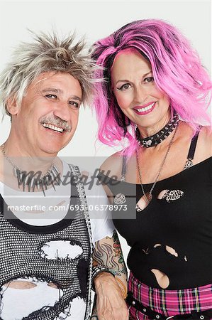 Porträt von Alter Punk paar stehend mit Arm in Arm über den grauen Hintergrund