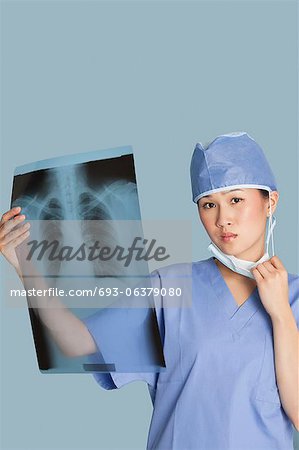 Porträt des weiblichen Chirurgen halten Röntgen Bericht über hellblauen Hintergrund