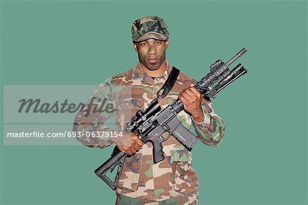 Porträt eines jungen Soldaten African American US Marine Corps mit M4-Sturmgewehr auf grünem Hintergrund