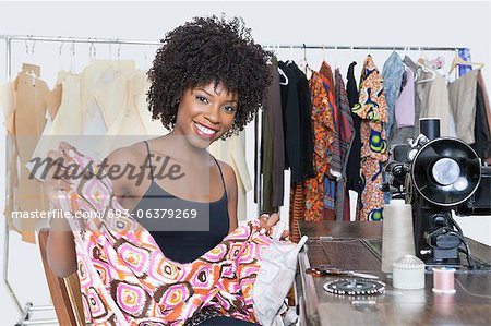 Portrait of an African American female fashion designer holding pattern cloth