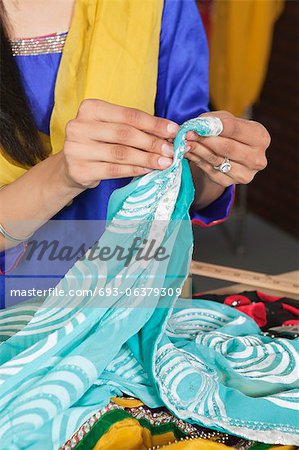 Midsection of dressmaker working on a sari