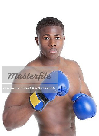 Porträt eines jungen Boxer tragen Boxhandschuhe im Kampf gegen die Haltung gegenüber dem grauen Hintergrund
