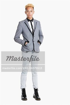 Portrait of a teenage boy standing in smart casuals over gray background Portrait of a teenage boy standing in smart casuals over gray background