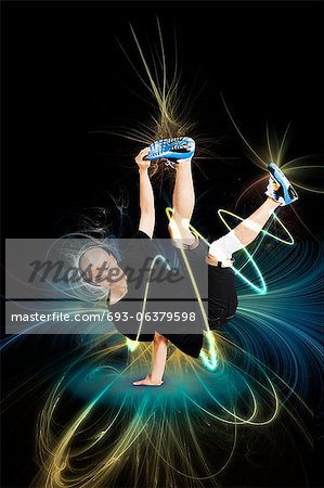 Break dancer performing handstand over blue background