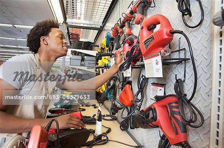 Homme afro-américain travaillant dans un magasin d'électronique Homme afro-américain travaillant dans un magasin d'électronique