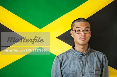 Portrait d'un homme avec des sourcils élevés contre drapeau jamaïcain