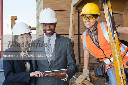 Portrait of engineers and female industrial worker smiling