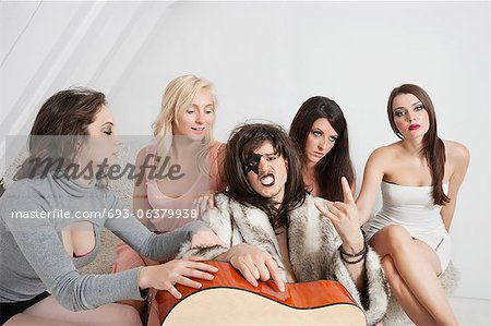 Young male guitarist with a cool gesture amid female group
