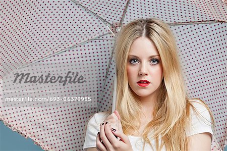 Close-up Portrait of young Woman holding Polka Dots Regenschirm