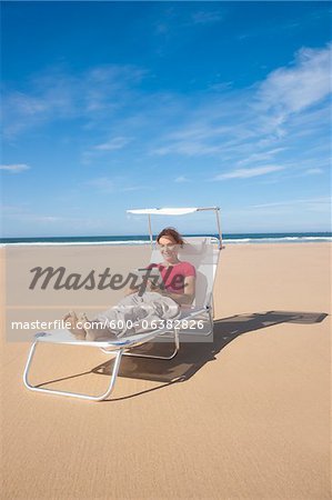 Frau mit Tablet am Strand, Camaret-Sur-Mer, Halbinsel Crozon, Finistere, Bretagne, Frankreich