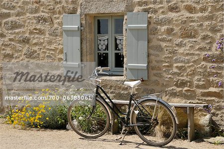 Vélo garé par la fenêtre et banc