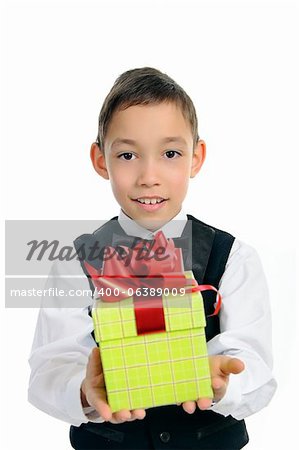 souriant garçon en costume noir holding boîte cadeau vert avec noeud rouge isolé sur fond blanc