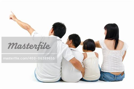 Rear view of Asian family looking at side, sitting on white background