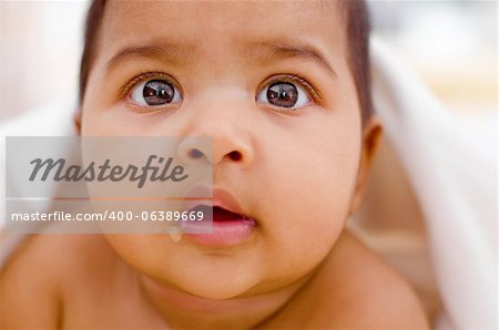 Curious Indian baby girl drooling and looking at camera