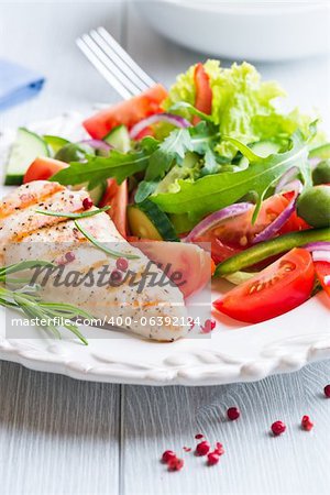 Gegrilltes Hähnchenfilet mit mediterraner Salat auf einem Teller