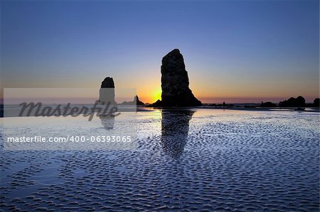 Roches aiguilles Haystack à Cannon Beach Oregon Coast marée basse au coucher du soleil