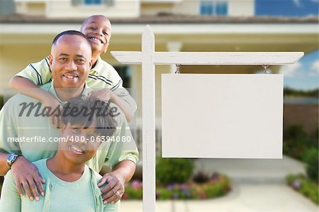 African American Family In Front of Blank Real Estate Sign and New House.