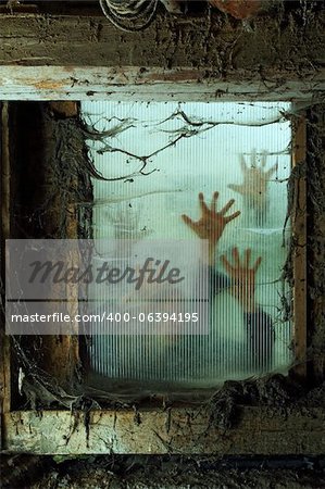 Photo of zombies outside a window that is covered with spiderwebs and filth.