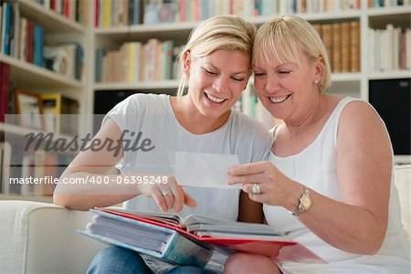 Family happiness and memories, happy mom and daughter looking at pictures in photo album
