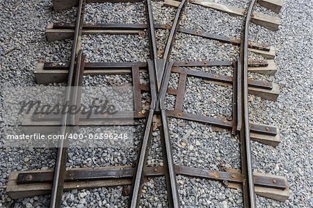 Jonction avec la voie ferroviaire sur un lit de gravier.