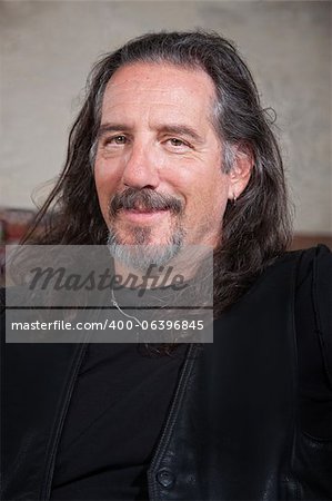 Smiling long haired male with leather vest