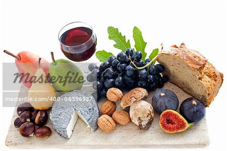 local speciality goat cheese, fruits and glass of wine in front of white background