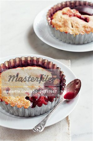 Plum Tarts on Plates with Spoons