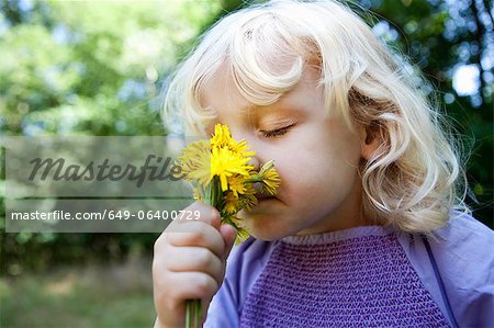 Girl smelling wildflowers outdoors