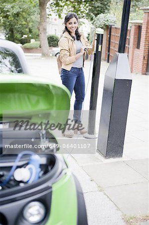 Frau Ladestation Elektroauto auf die Straße