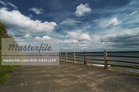 Wooden posts on paved coastal road