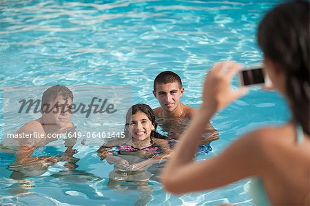 Femme, prendre des photos de famille dans la piscine