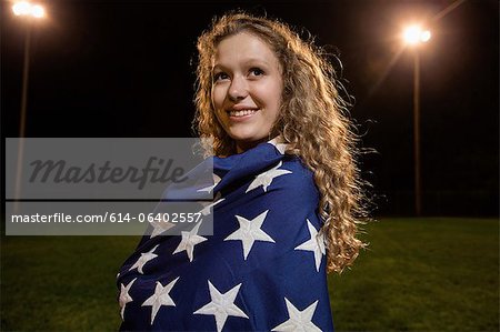 Fille enveloppé dans le drapeau américain dans la nuit